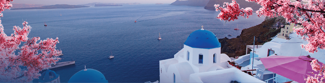 Beautiful view of Oia, Santorini, Greece with pink blossoms flowers at beautiful spring sunset  Vintage colored picture  Business, Love and travel concept