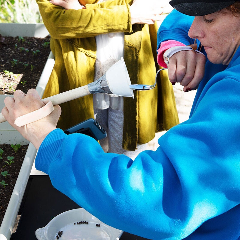 Adaptive tools can be fashioned from everyday materials such as spoons, funnels, duct tape and PVC pipe. Here, a patient is able to independently plant seeds using adaptive tools.