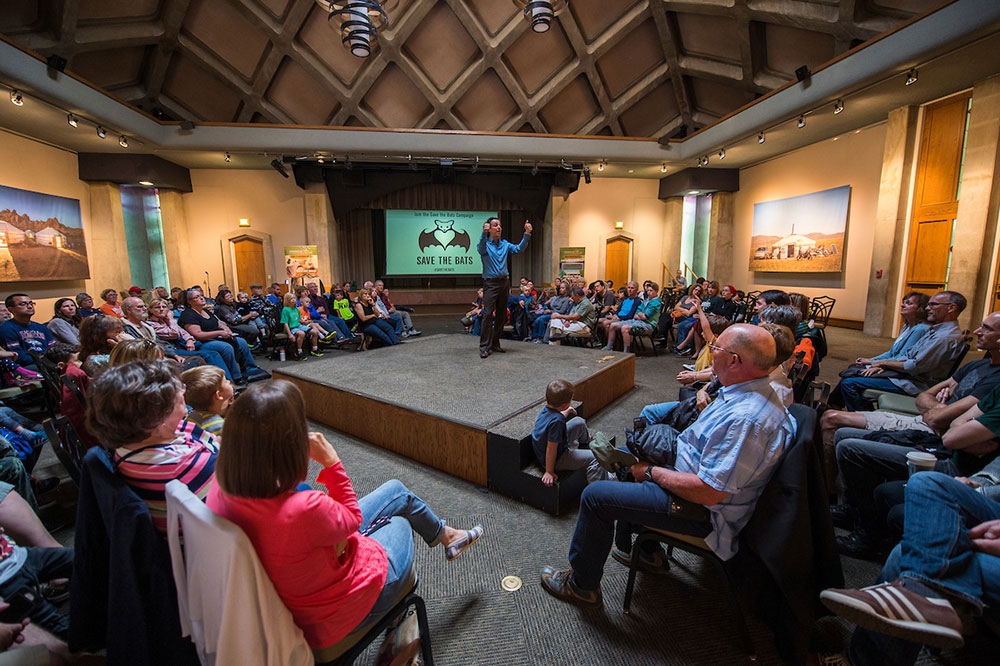 A speaker on a center stage in Mitchell Hall