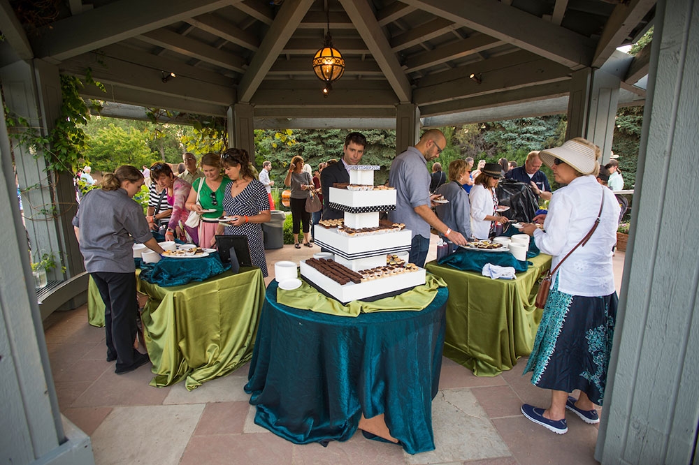 People gathering to eat cake under the gazebo