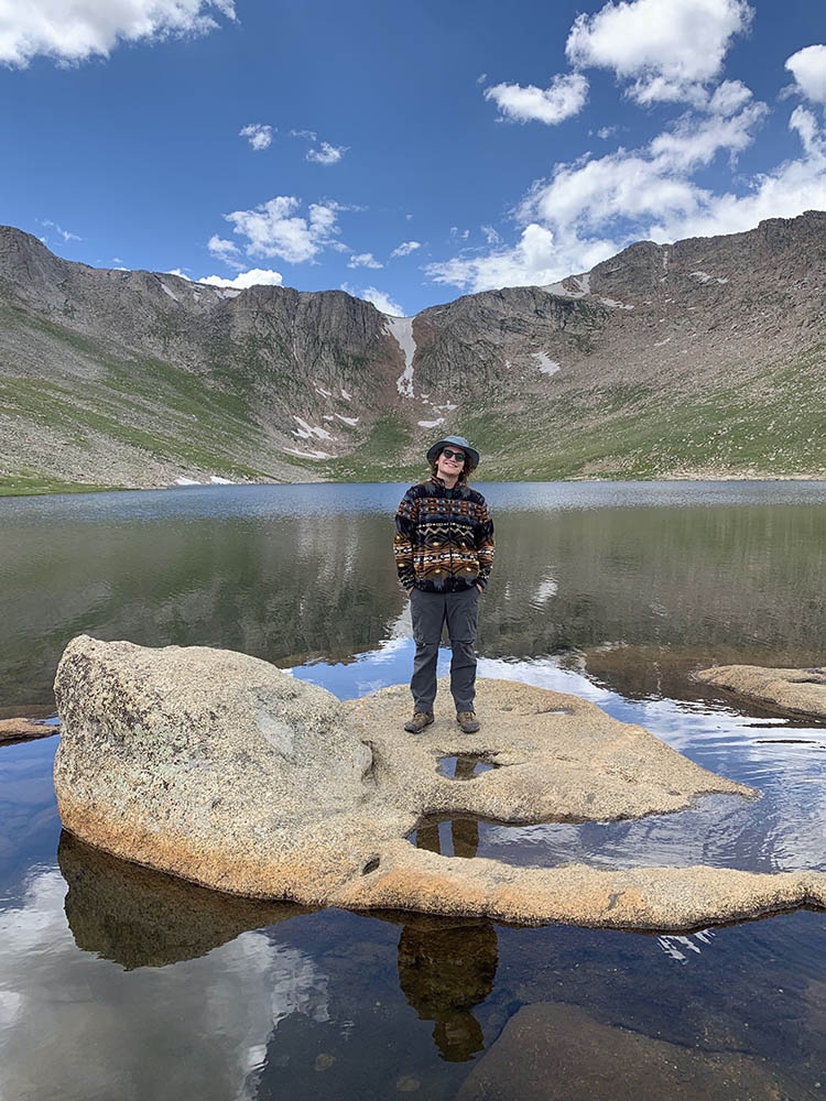 Man standing on rock in mountain lake.