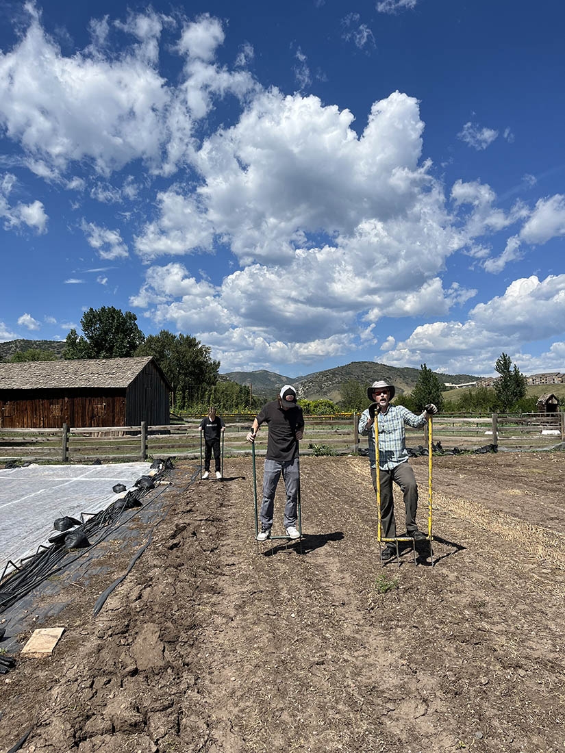 two people with broadforks on a farm