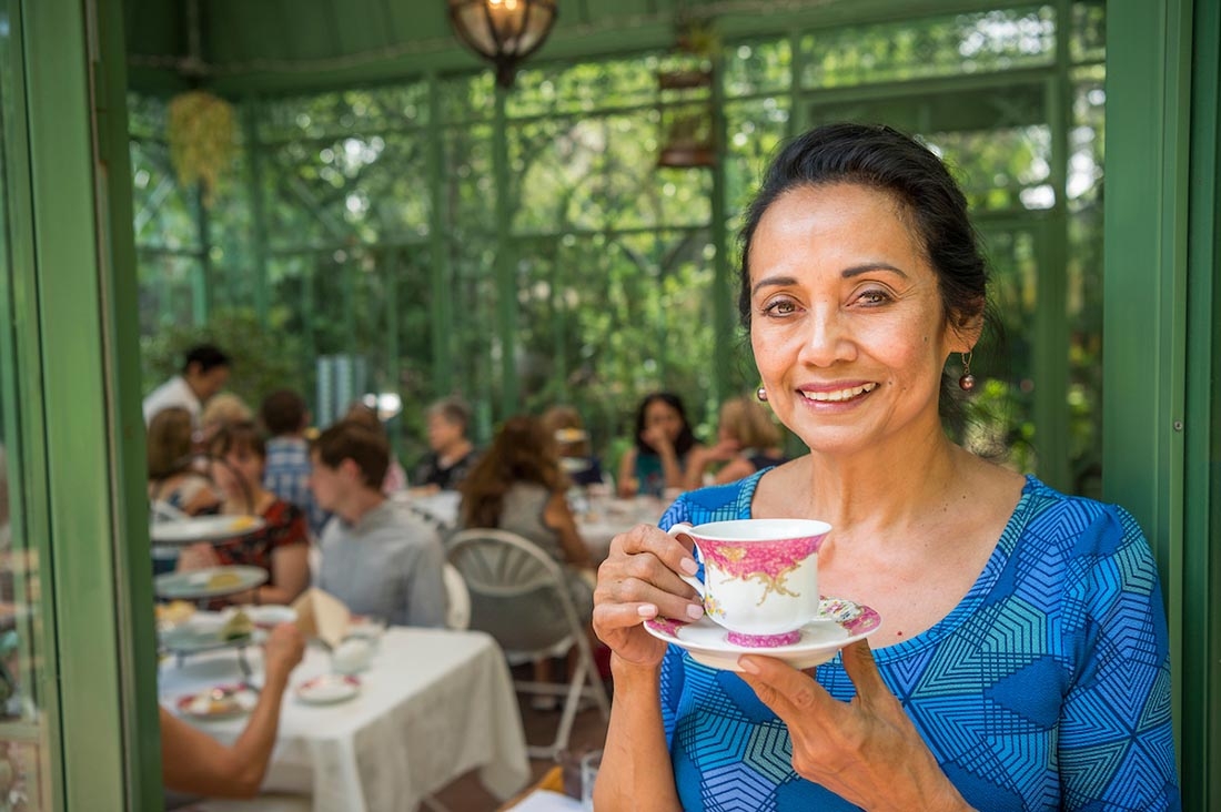 Woman smiling with tea cup in Solarium doorway
