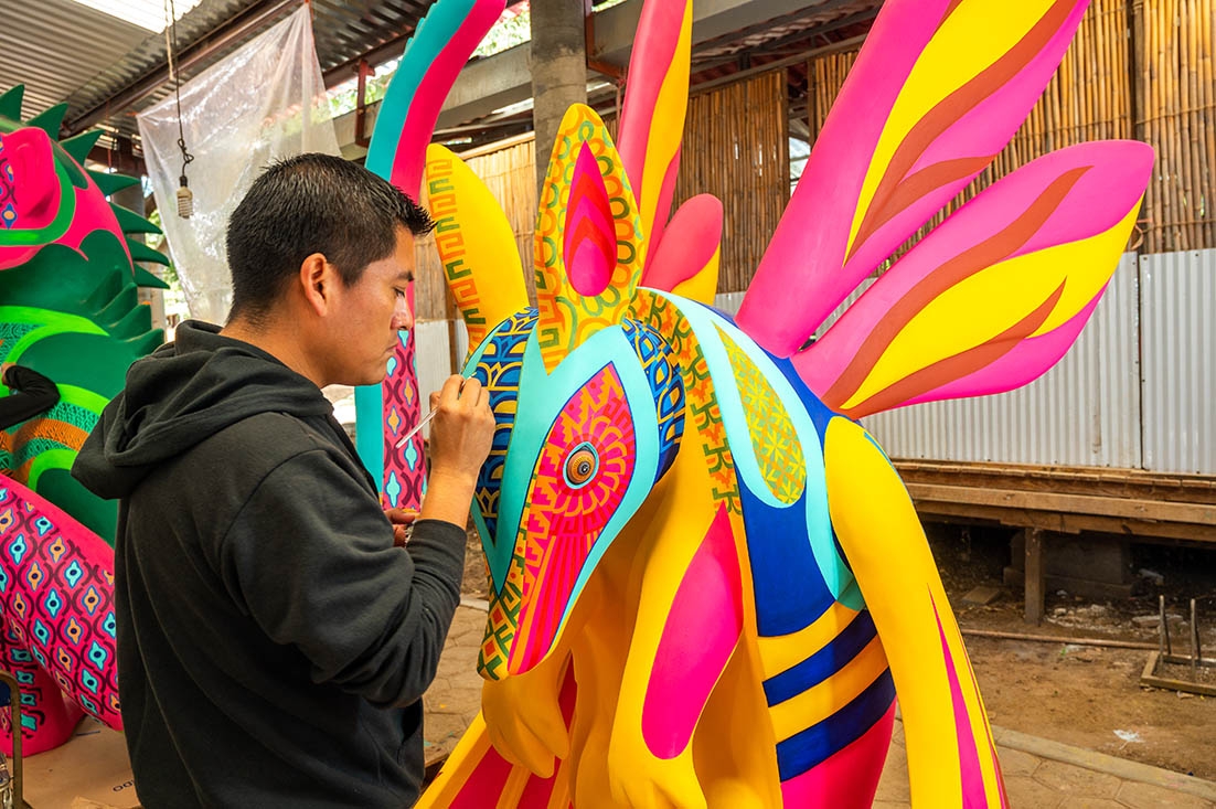 artist painting an alebrijo sculpture