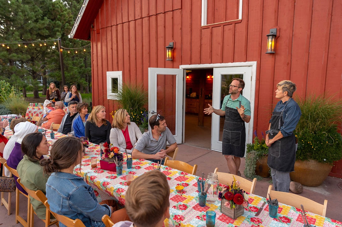 Dinner table set in front of a barn