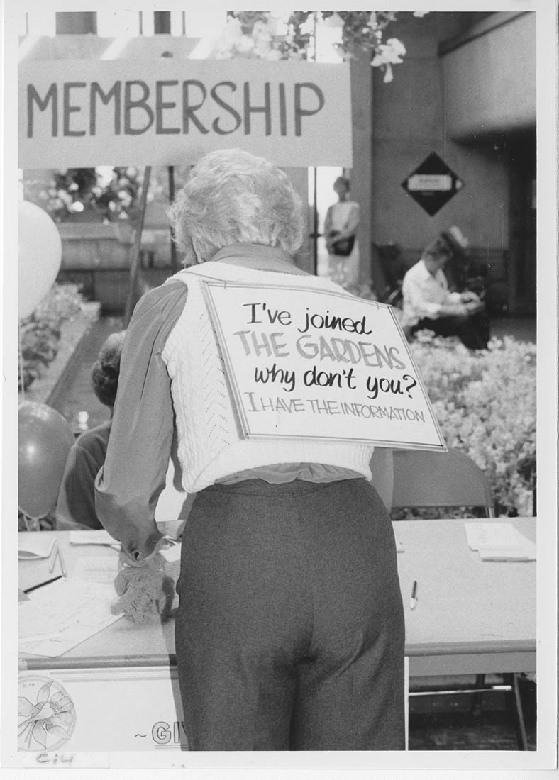 Black and white photo women wearing sign on back