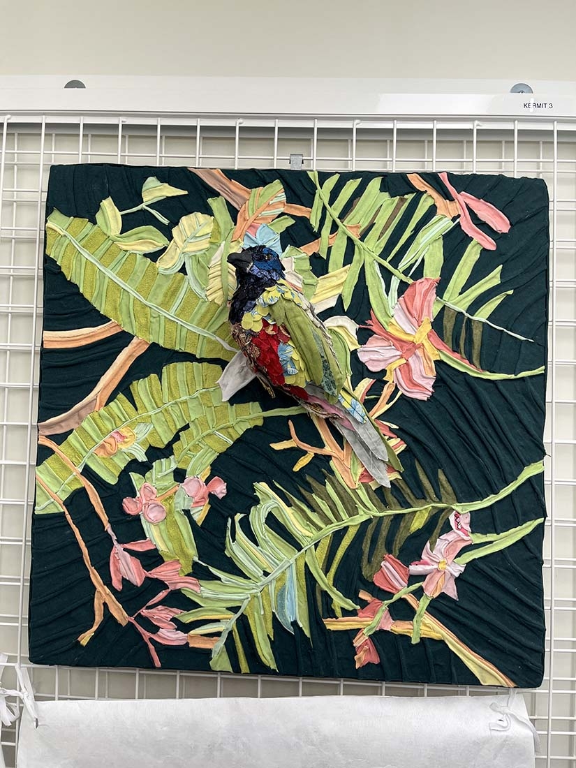 3D bird made of discarded textiles against leafy background