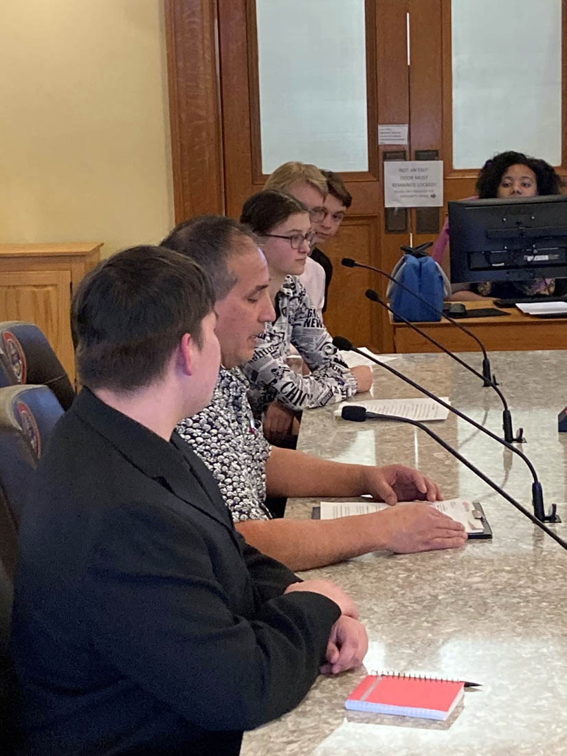 People sitting at table during committee meeting