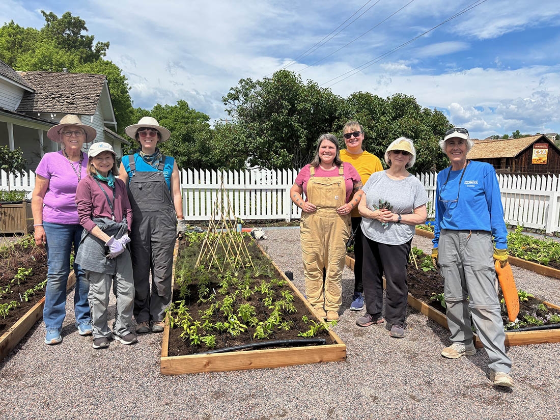 staff stand on either side of a newly planted garden bed